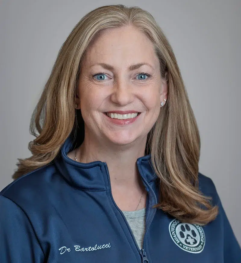 Dr. Jennifer Bartolucci smiling in a navy jacket with a veterinary clinic logo.
